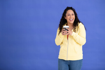 Studio portrait of mid adult woman in yellow sweatshirt