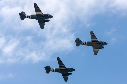 Farnborough, UK - July 20, 2014: Three World War II era Douglas C-47 (DC-3) transport aircraft with D-day invasion stripes flying in formation..