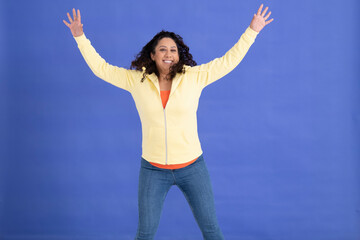 Studio portrait of mid adult woman jumping