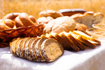 lot of different flavored bread, wheat, rye, on the table in the field outside