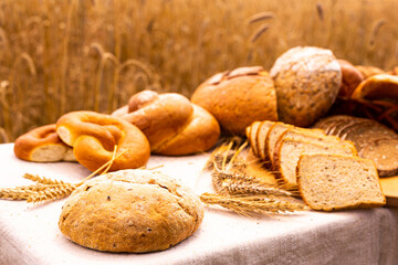 lot of different flavored bread, wheat, rye, on the table in the field outside