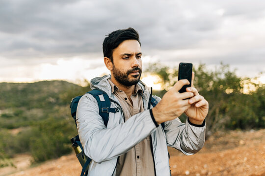 Man hiking and taking pictures with smartphone in Brazilian Caatinga