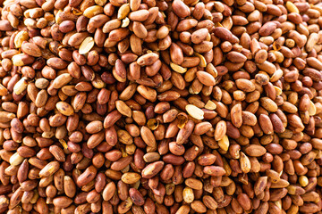 Red unpeeled peanuts panoramic view background