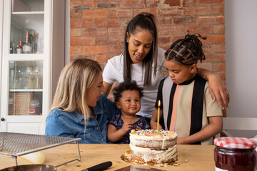 Mothers and sons celebrating birthday with cake