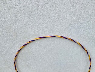 the arch of a colorful hoola hoop in front of a white wall © Marcus