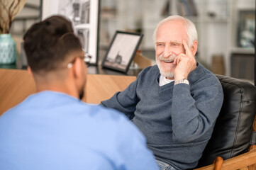 Happy elderly person talking to his in-home caregiver