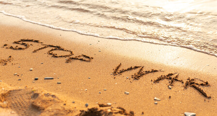 Words written in the sand on the beach. The words Stop War and written in the Sand with the Ocean in the background. Protest War sign written in sand. World Peace. No War