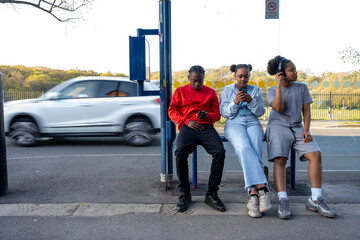 Friends sitting at bus stop