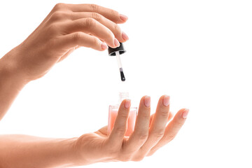 Female hands with beautiful french manicure holding bottle of pink nail polish against white background