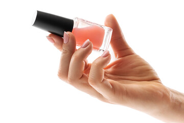 Female hand with beautiful french manicure holding bottle of pink nail polish against white background