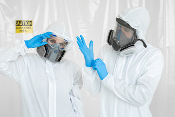 Portraits of the doctor: a man and a woman in protective suits and respirators, wearing gloves during quarantine. Covid-19.
