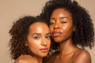 Studio portrait of two women cheek to cheek