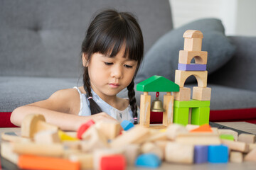 Cute Asian little girl playing with colorful toy blocks, Kids play with educational toys at kindergarten or daycare. The creative playing of the kid development concept, Toddler kid in the nursery.