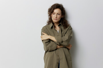 Thoughtful unhappy sad curly beautiful woman in casual khaki green shirt suffering from bad relationship posing isolated on over white background. People Emotions Lifestyle concept. Copy space