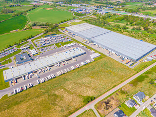 Aerial view of warehouse storages or industrial factory or logistics center from above. Top view of industrial buildings and trucks