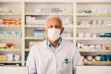 Portrait of a senior pharmacy worker looking at the camera during corona virus.