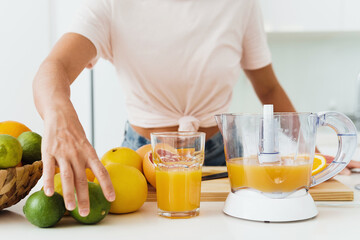 Glass of orange juice and citrus juicer on the kitchen table