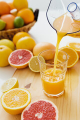 Pouring of fresh orange juice into the glass
