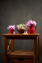 Bouquets of crocuses and snowdrops in clay vases on a wooden table. Peace and tranquility