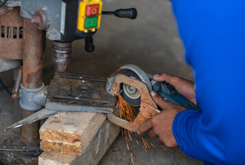Worker grinding to cut a steel without gloves.