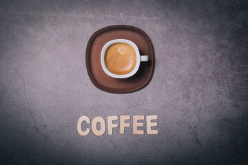 Espresso Coffee drink and wooden text word made with wooden letter on a black textured surface