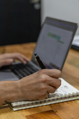 Hand on computer and writing notes - Office work