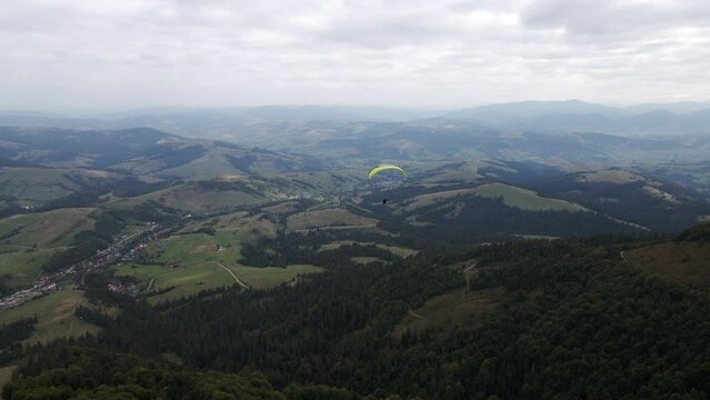 following after paraglider flying above ukrainian carpathian mountains