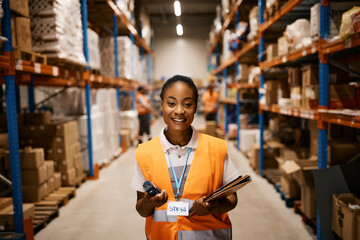 Portrait of happy black female warehouse manager looking at camera.