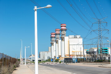 Fototapeta na wymiar three chimneys of a power plant on a clear day against a clear sky