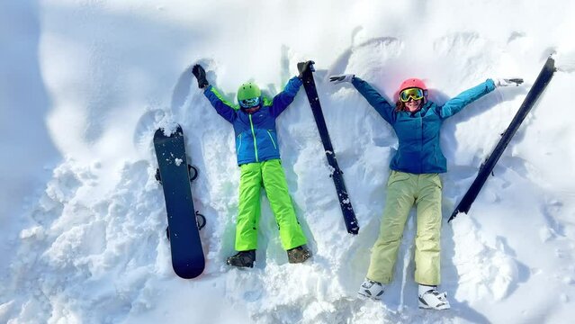 Ski woman and young boy with snowboard view from above