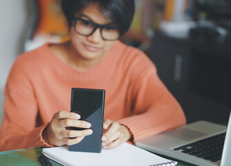 Female investor, watch stock market, via mobile phone Staying at home, planning index growth and planning investments.