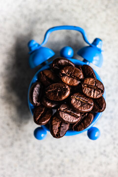 Roasted coffee beans on a vintage alarm clock as a morning wake up concept