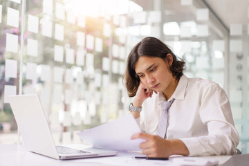 Business concept, Businessman reading financial report and analyze to make project on laptop