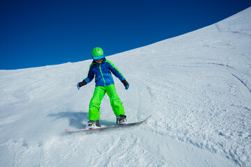 Action photo of boy snowboard down mountain slope fast