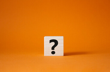 Question mark symbol. Concept words question mark on wooden cube. Beautiful orange background....