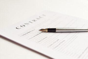 The pen is on the contract and the contract is on a white background. Hight quality photo