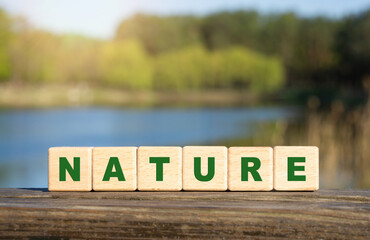Word NATURE made from letter blocks outdoors