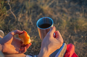 Man with cup of tea and apple have the rest after hiking