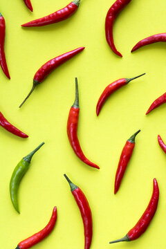Cayenne or chilli pepper on a yellow background pattern. Vegetables on colored background, creative picture