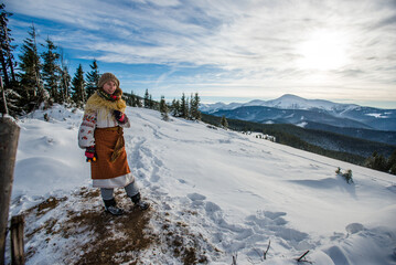 Tourist girl in traditional ukrainian clothes in the winter Carpathian mountains