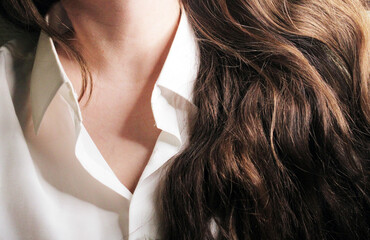 A beautiful girl in a white shirt with loose long dark hair.
