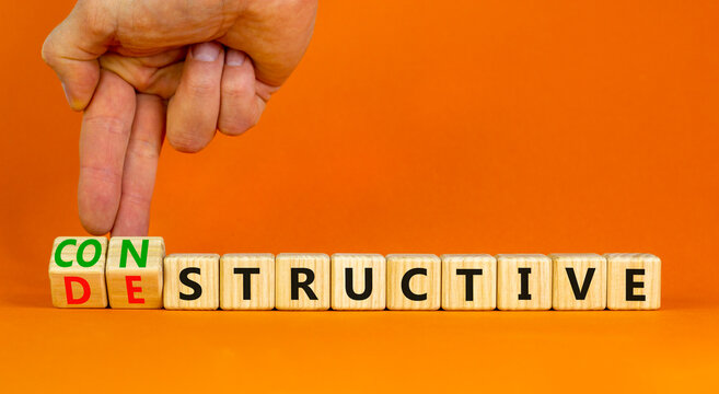 Destructive or constructive symbol. Businessman turns cubes changes the concept word Destructive to Constructive. Beautiful orange background. Business constructive destructive concept. Copy space.
