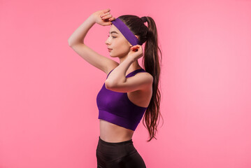 Athletic girl in fashionable sportswear on colorful pink background