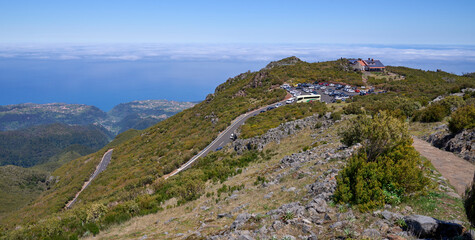 Fototapeta na wymiar Panorama of Achada do Teixeira, plateau with refuge, natural rock formations and a trail to the nearby Pico Ruivo, the highest peak in Madeira Island. Clouds and the Atlantic Ocean at the background.