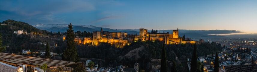 Fototapeta na wymiar Panoramic photography of the Alhambra and the castle of Carlos V in the background is the Sierra Nevada and the city of Granada in Spain, from the plaza del mirador de San Nicolas during sunset