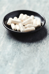 Fototapeta na wymiar Beta-alanine capsules. Bodybuilding food supplements on wooden background. Close up. Copy space. 