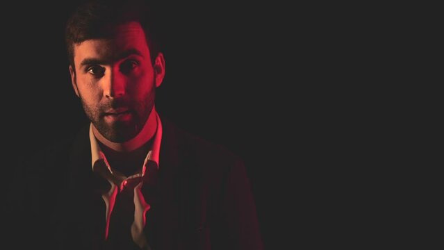 4k video of positive man posing on black background with pink light.