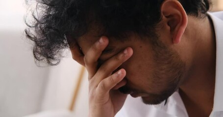 Face of thoughtful young Indian man at home
