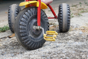 Naklejka premium close up wheel of old tricycle on dirty concrete ground