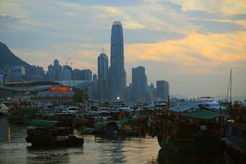 Fototapeta na wymiar junk boats with the backlit of skyscrapers in Hong Kong island, the view of typhoon shelter